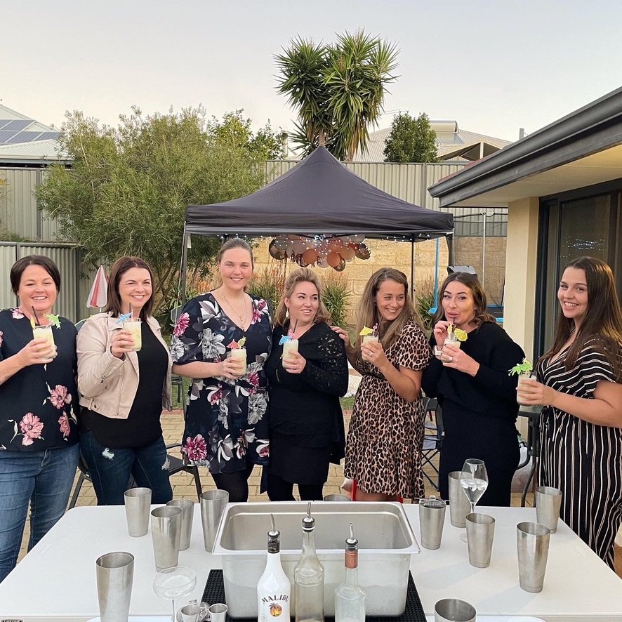 A group cheering at a backyard cocktail class