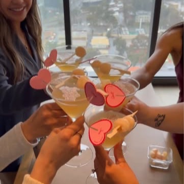 Guests cheering with cocktails in a high-rise with a view over the city