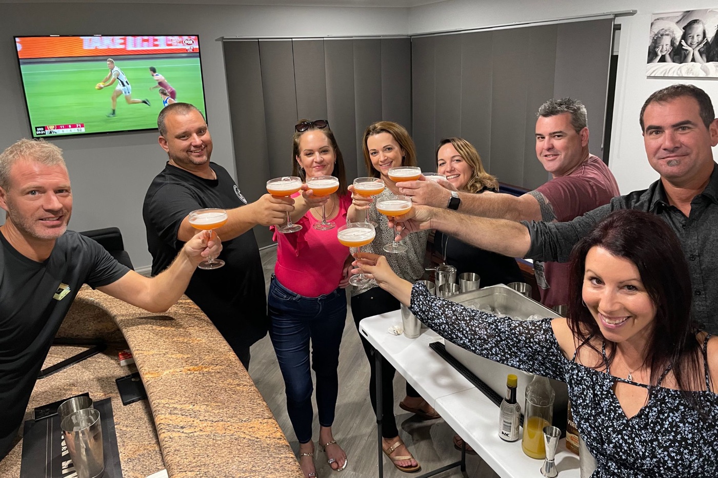 A mixed group raising the cocktails they made together